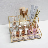 Gold-framed glass makeup organizer with tiered compartments in luxury brass vanity style